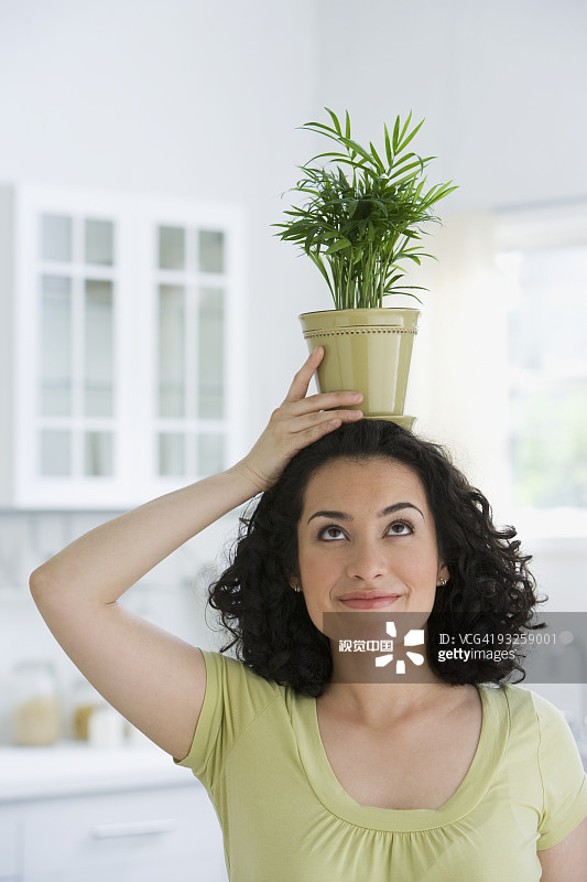 一名西班牙妇女头上顶着盆栽图片素材
