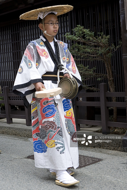 身穿传统长袍和帽子男青少年行走图片素材