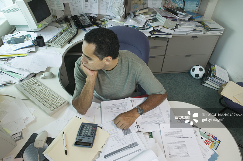 高角度的看法，一个商人坐在椅子上，他的手在他的下巴图片素材