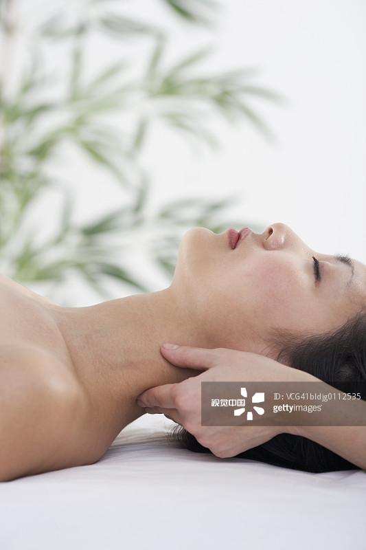 侧面的中年妇女得到一个颈部按摩图片素材