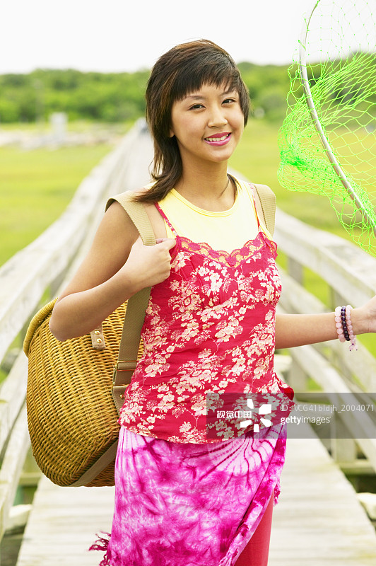 拿着篮子和渔网的年轻女子图片素材