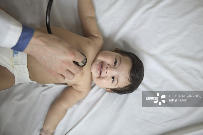 高角度拍摄的医生检查男婴图片素材