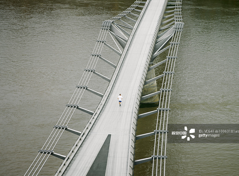 英格兰伦敦，千禧桥上慢跑的男人鸟瞰图图片素材