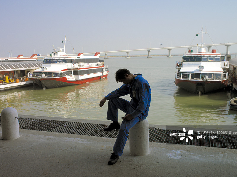 中国澳门：港口工人休息，背景是渡轮图片素材