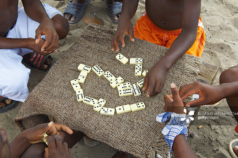 在沙滩上玩多米诺骨牌的男人和男孩图片素材