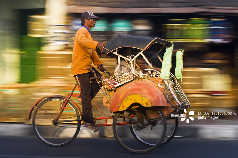 印度尼西亚爪哇日惹街头乘坐三轮车的人（虚化效果）图片素材