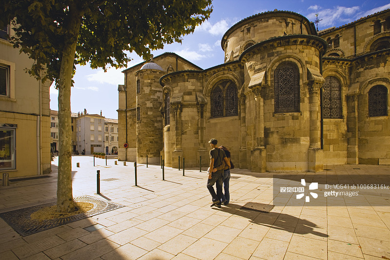 法国罗纳-阿尔卑斯，罗纳河谷，德龙省瓦朗斯，年轻夫妇路过圣阿波利奈尔大教堂图片素材